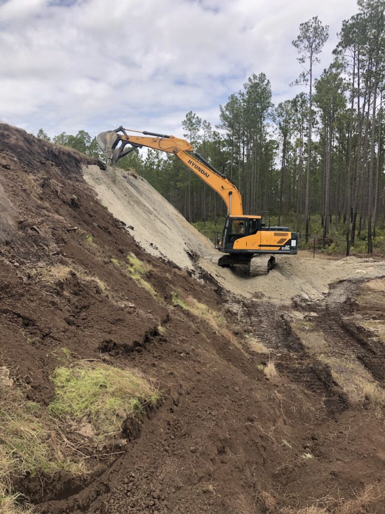 Excavator repairing dirt berm Green Pro Insurance